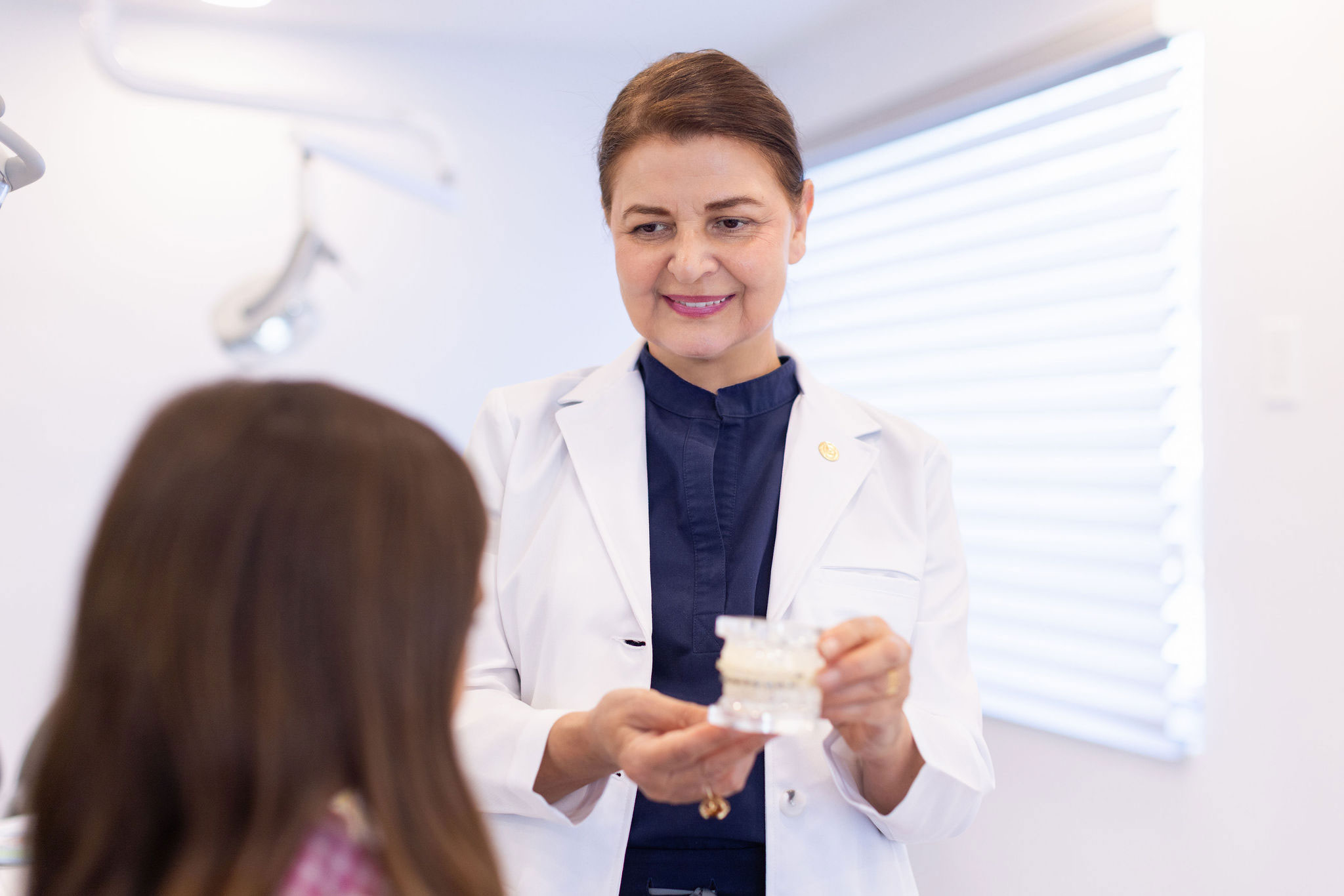 Dr. M. Azadeh Afzali discussing treatment with a young patient